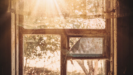 Bright rays of sun shining in vintage room through aged wooden frame of window