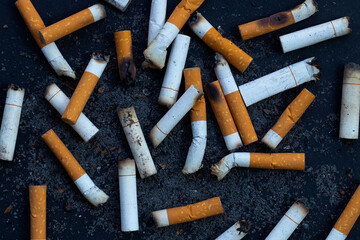 Cigarettes buds with ashtray on dark background.
