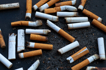 Cigarettes buds with ashtray on dark background.