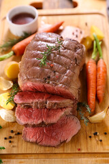 roast beef with vegetable on wooden board