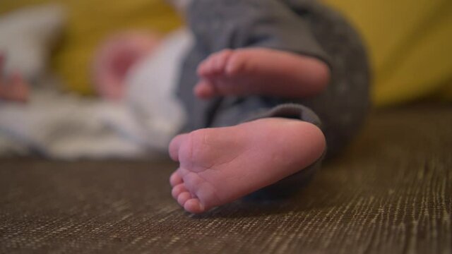Close-up shot of a baby delicate feet moving while the boy is crying, blurred bokeh