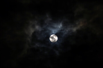 The Moon behind the clouds. The moon in a partially clouded colorful sky.