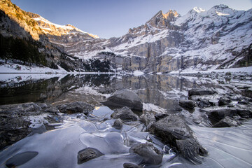 Dans les alpes suisses, photos d'un lac de montagnes avec la neige et des reflets.