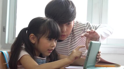 School children using digital tablet device in school classroom , digital native, technology, learning, touchscreen. Diversity group of students in class.