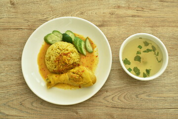 rice cooked with chicken in curry on plate and soup cup