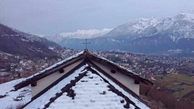 Drone 4K 30fps footage in Levico terme of the S. Biagio church, with frescoes dating back to the 13th &ndash; 16th centuries in Levico Terme, italy, trento, surrounded by the city, mountains and the lake. 