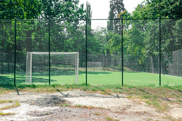 Soccer field behind the iron fence. Empty school soccer stadium