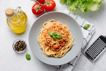 Traditional italian pasta spaghetti with bolognese meat sauce and parmesan on a light concrete, stone background