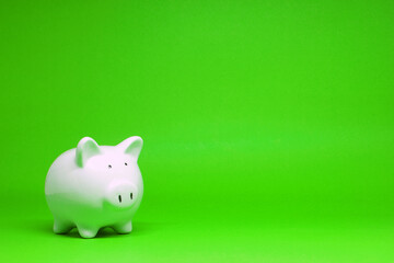 White Piggy bank on green background with copy space for text message - Fund , Investment , Saving money - green concept of Banking and Stable financial