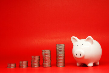 Fund , Investment , Saving money concept : White Piggy bank and coin on red background with copy space for text messag - red pattern of Banking and finance , loan and benefit concept 