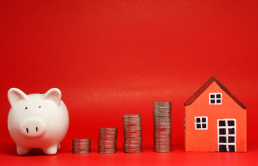 Fund , Investment , Saving money concept : White Piggy bank coin and House on red background with...