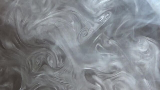 黒い背景に空中を漂うタバコの呼出煙。喫煙、受動喫煙。