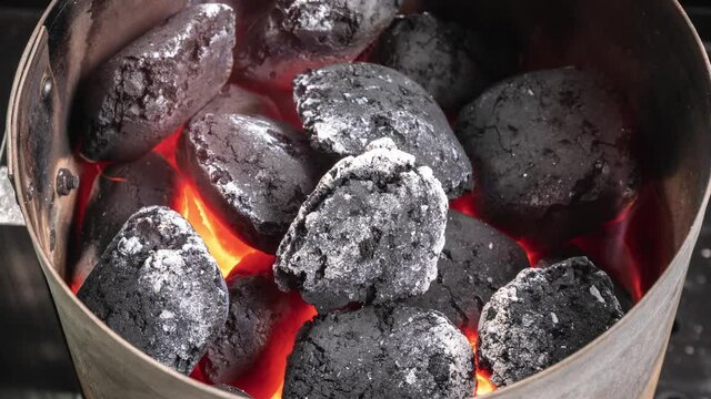 Time lapse of a burning charcoal barbecue briquettes in a chimney grill starter.