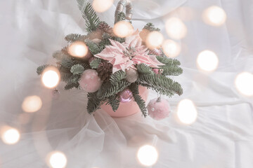 Christmas composition with pink shiny balls, berries are on natural Finnish fir on light background with bokeh.