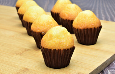 Close up, freshly baked small muffins on bamboo table.
