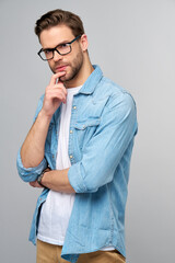 Portrait of young handsome caucasian man in jeans shirt over light background