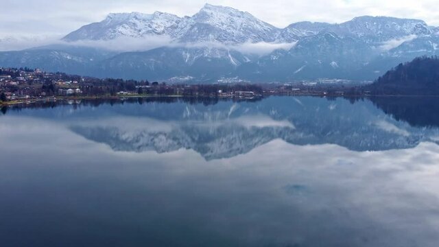 Drone aerial video footage above the Levico lake, facing the mountain Pizzo di Levico, with Forte Spitz Vezzena on the very top. Flying above the water