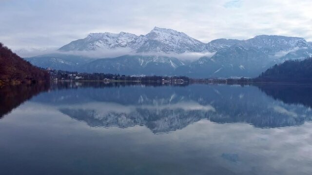 Drone aerial video footage above the Levico lake, facing the mountain Pizzo di Levico, with Forte Spitz Vezzena on the very top. Flying above the water