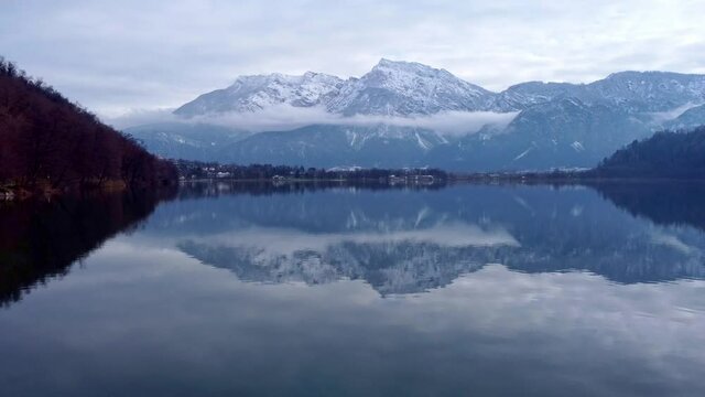 Drone aerial video footage above the Levico lake, facing the mountain Pizzo di Levico, with Forte Spitz Vezzena on the very top. Flying above the water