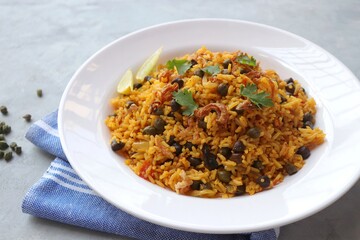 Indian cuisine - Chickpeas Biryani, chole Pulao. Garnished with fried onion, chopped coriander, and lemon wedges. Kala chana biryani. Along with copy space.  