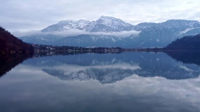 Drone aerial video footage above the Levico lake, facing the mountain Pizzo di Levico, with Forte Spitz Vezzena on the very top. Flying above the water