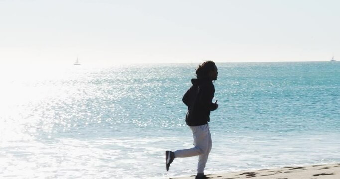 Afro man running along the beach