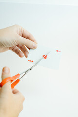 hands cutting the ace of hearts card with scissors