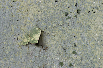 Peeling paint on the wall. Old concrete wall with cracked flaking paint. Weathered rough painted surface with patterns of cracks and peeling. High resolution texture for background and design. Closeup