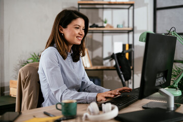 Businesswoman in office. Beautiful young woman working on computer at her workplace..