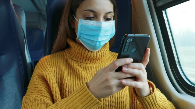 Tired student or office worker with surgical mask chatting with mobile phone to spend the time on the train