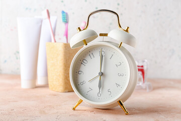 Alarm clock and set of oral care products on table