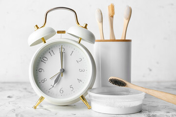 Alarm clock and toothbrushes on table