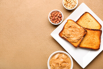 Bowl with tasty peanut butter, toasts and nuts on table