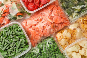 Containers and plastic bags with frozen vegetables as background