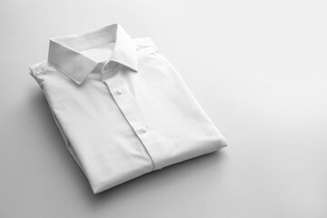 Folded male shirt on light background