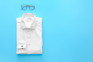 Folded male shirt on color background