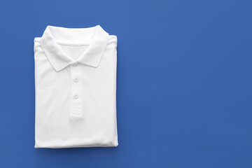 Folded polo shirt on color background