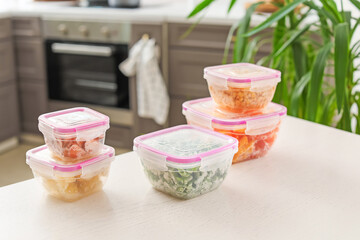 Plastic containers with frozen vegetables on table
