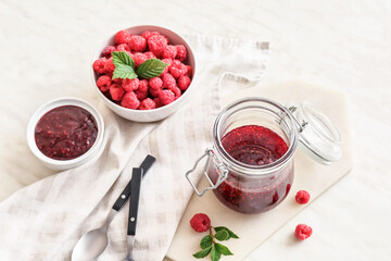 Jar with sweet raspberry jam on table