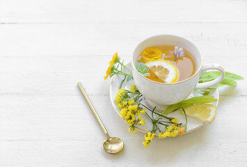 Cup with floral tea on light background