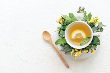 Cup with herbal tea on light background