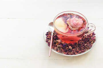 Cup with floral tea on light background