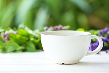 Cup with floral tea on table against blurred background