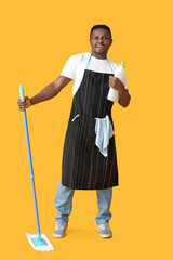 African-American man with mop and detergent on color background