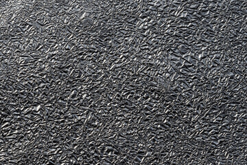 Winkled aluminium foil for desktop background. Shiny silver metalized texture close up 