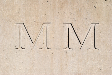 Close Up of Grey Concrete Wall with Incised Lettering 'MM' for Year 2000 