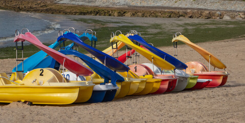 Fototapeta na wymiar Pedal boats on a beach shore