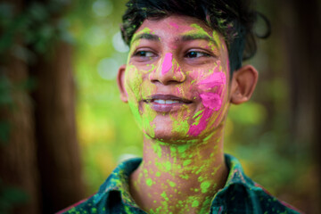  A young man with face full of colours enjoying holi celebration.Concept for Indian festival Holi.﻿