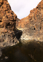 Gran Canaria, landscapes along the hiking route around the ravive Barranco del Toro at the southern part of the 
island, full of caves and grottoes, close to San Agustin resort, water is running in th