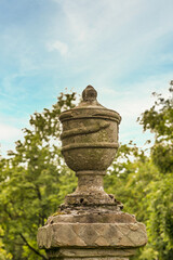 alte Urne wird von einer Schlange umringt © Blende8